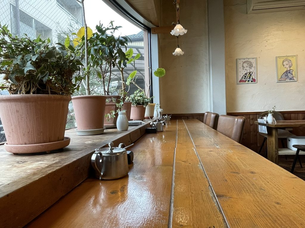 木のカウンターと植物が並ぶnori蔵コーヒーの店内
