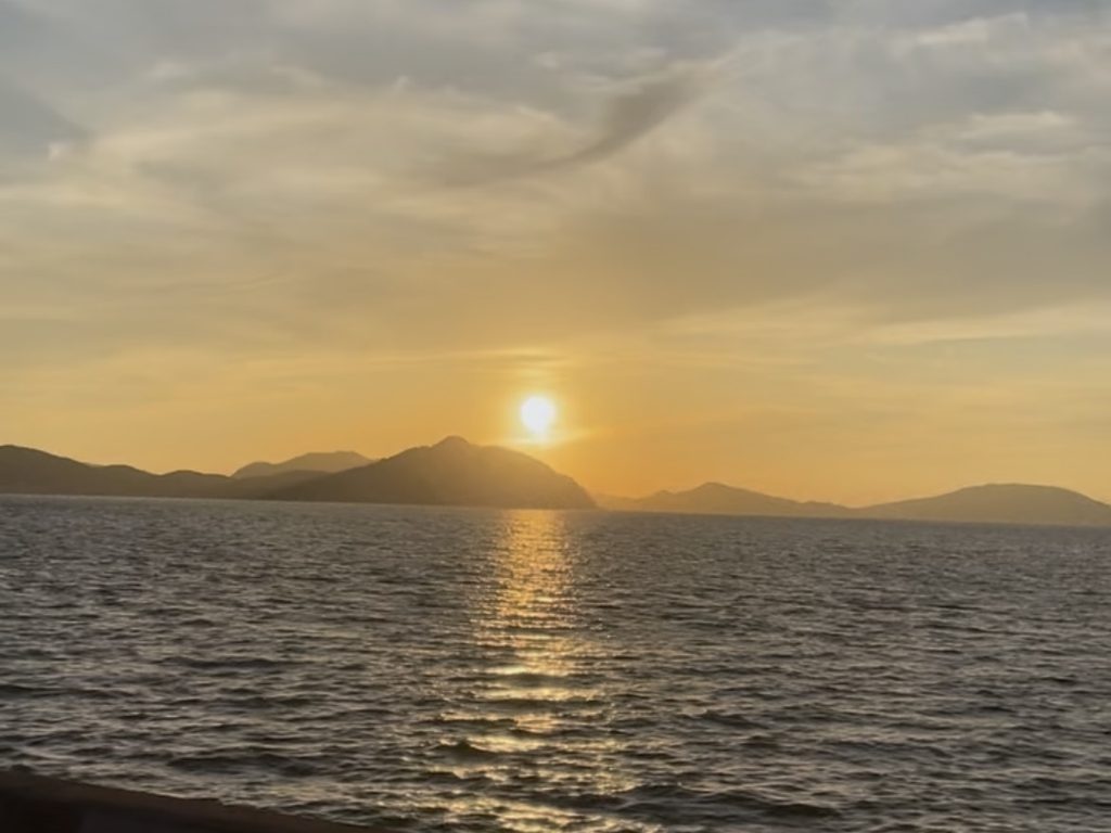 小戸公園から眺めた、海と山並みの上に輝く夕日