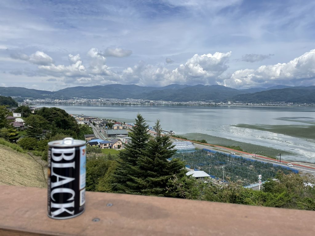 諏訪湖を背景に置いた缶コーヒー