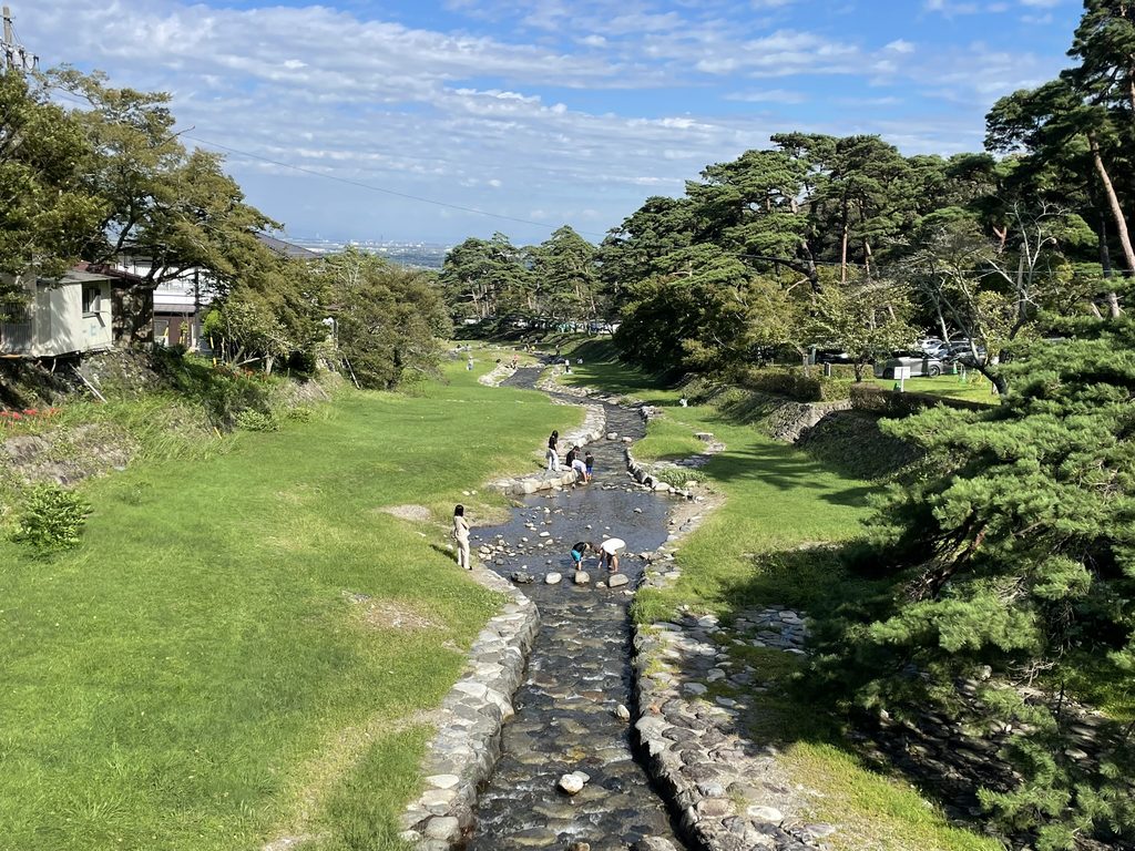 午後の養老公園を流れる川と水遊びをする人々