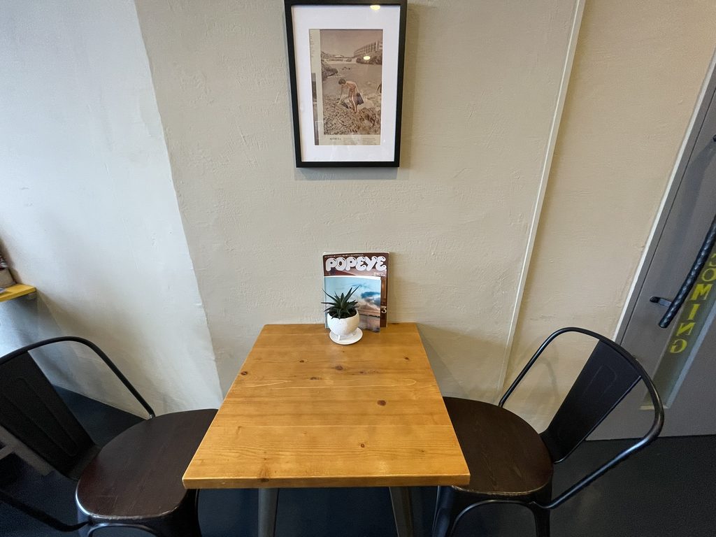 茶色いテーブルとアートが飾られたLAZY COFFEEの店内
