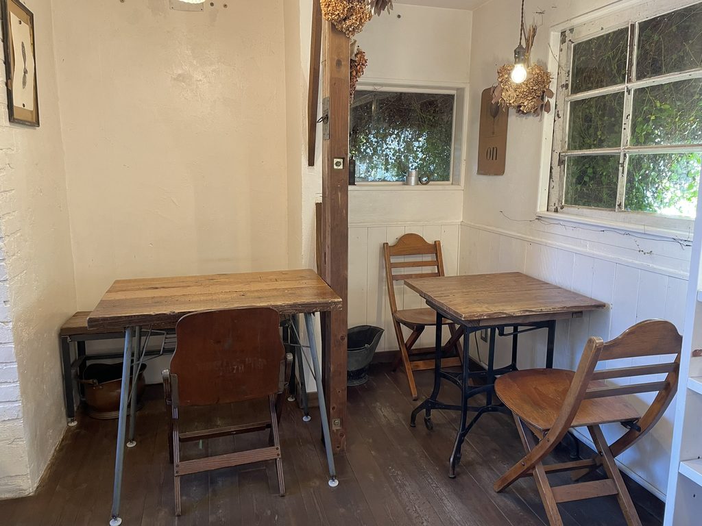 木製のテーブルと椅子が並ぶTHE DAY COFFEE STANDの店内