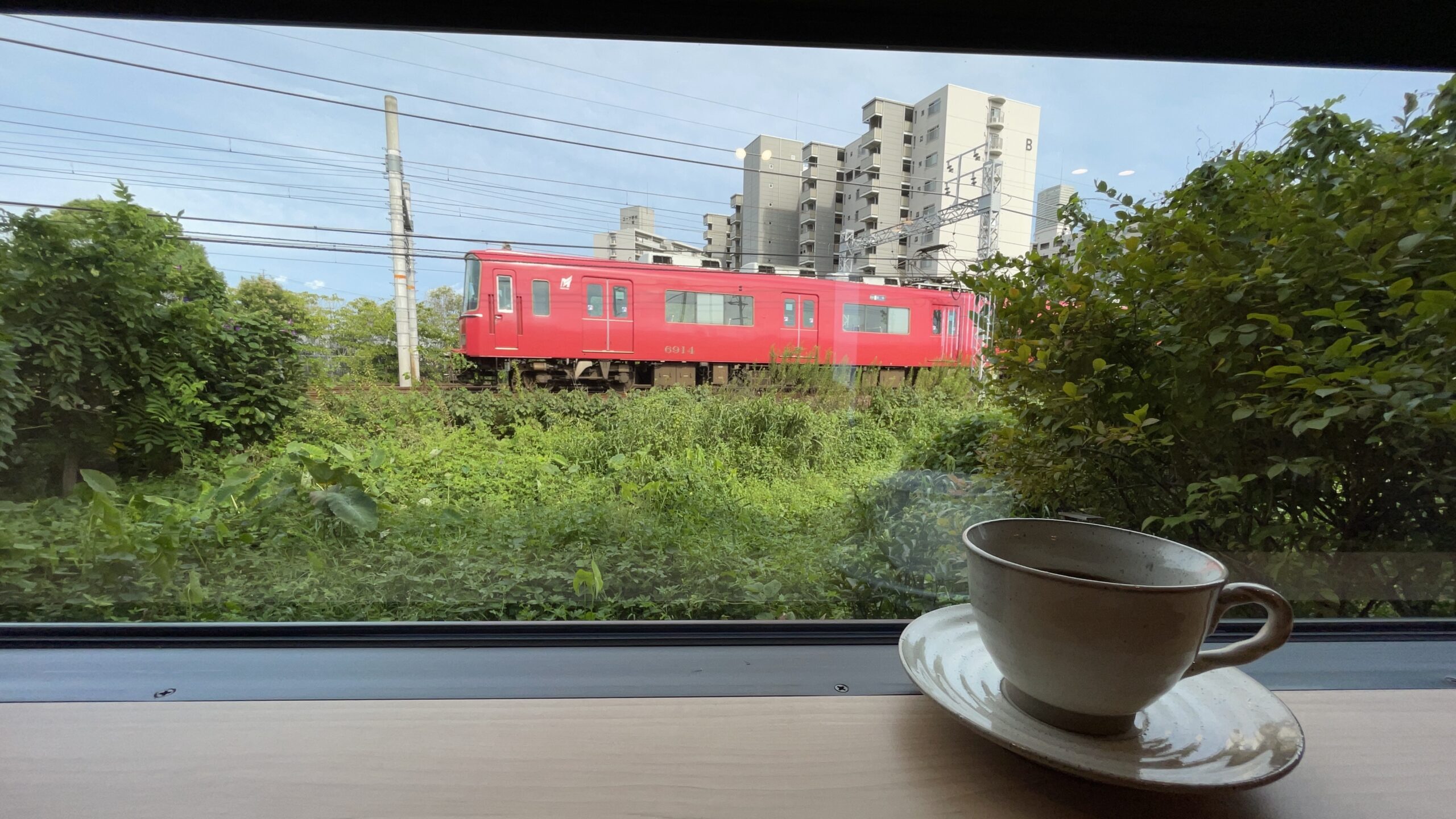 茶屋さくら・そうの窓際から眺める名鉄の赤い電車とコーヒー