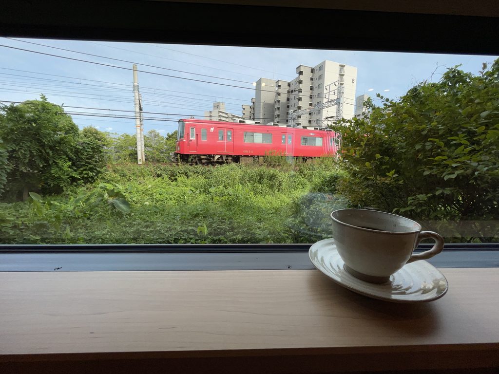 コーヒーカップ越しに眺める名鉄の赤い電車